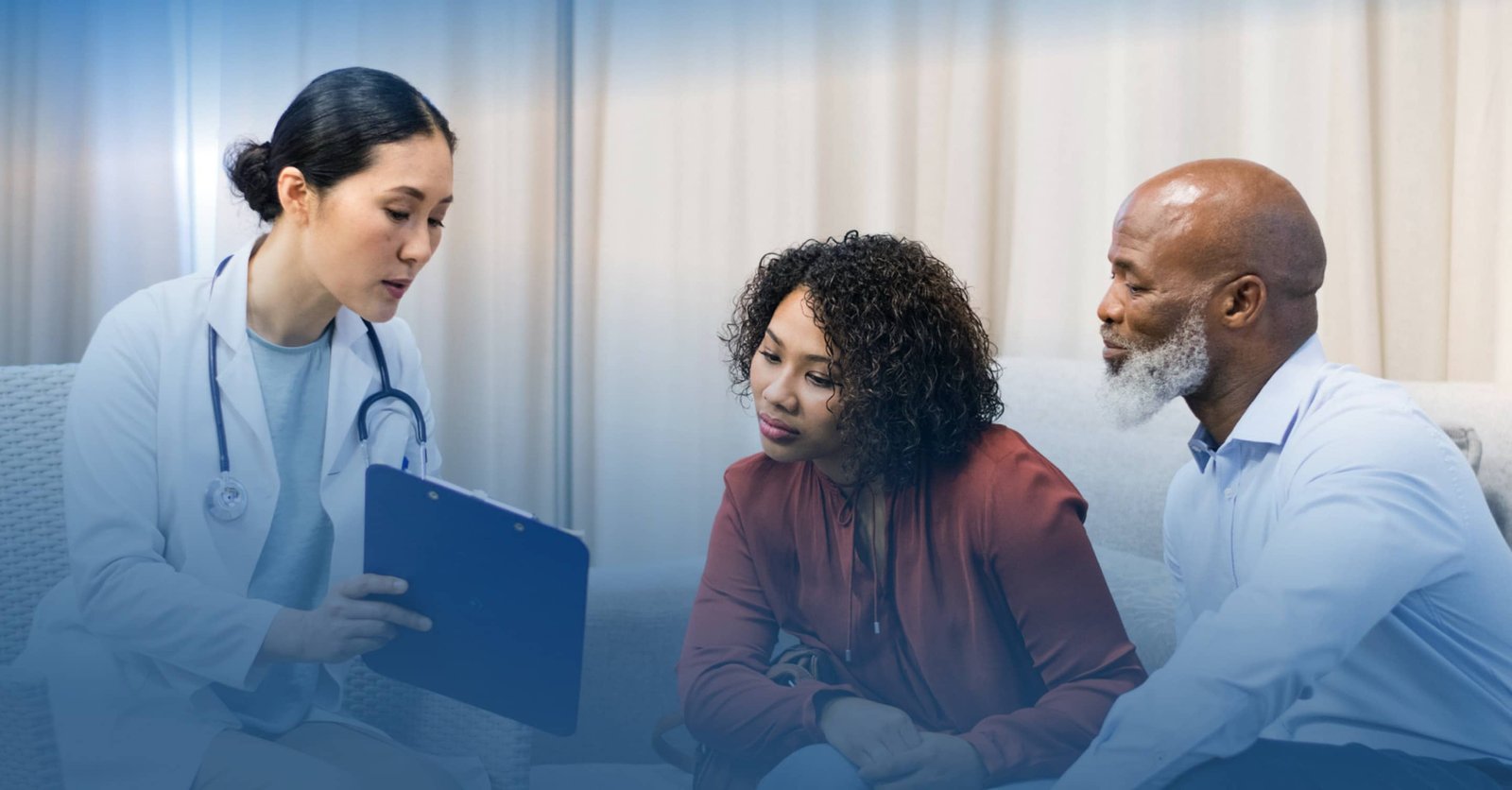 Healthcare professional sitting with two people