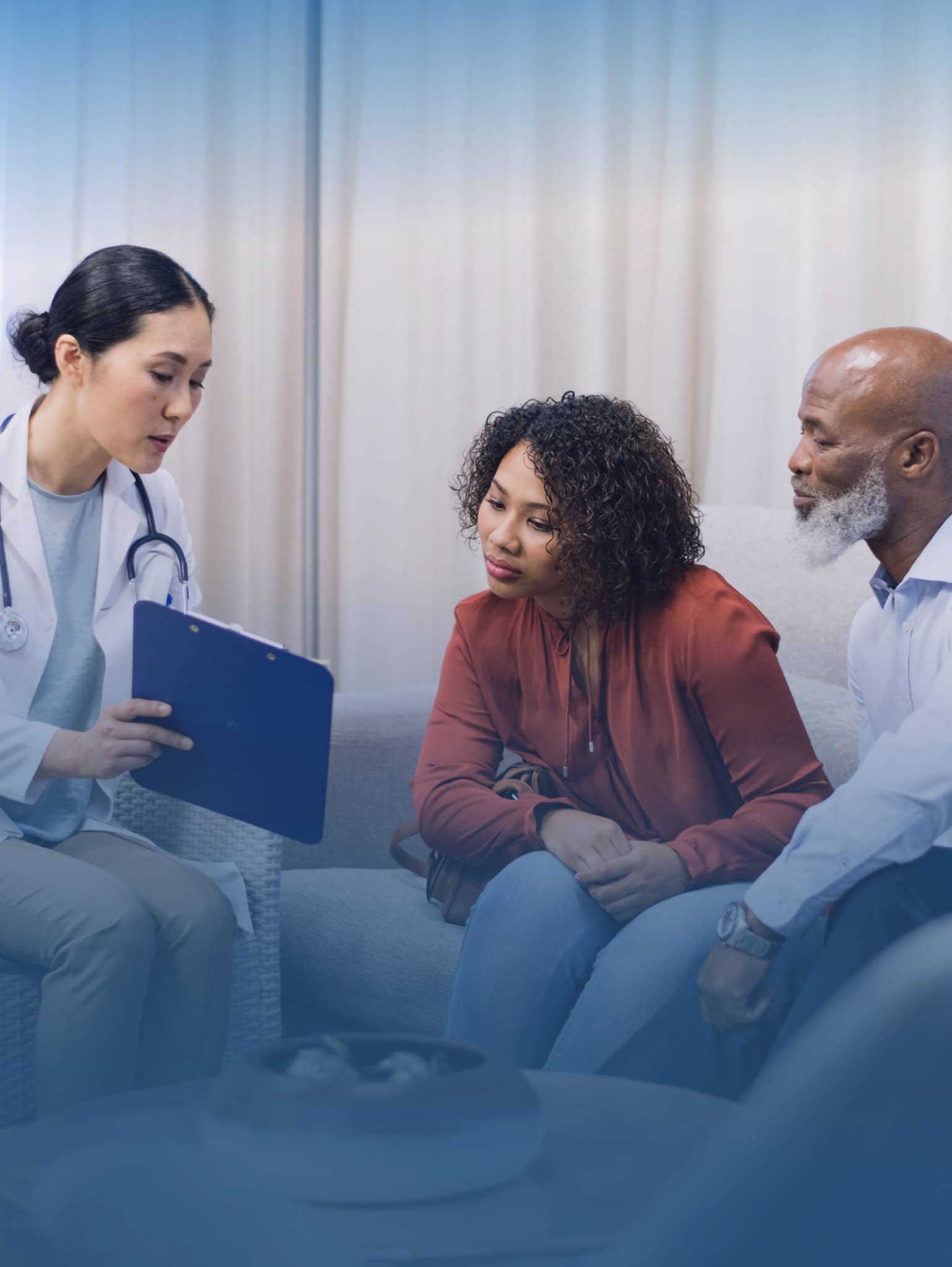 Healthcare professional sitting with two people