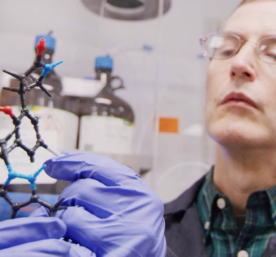Scientist looking at a molecule model